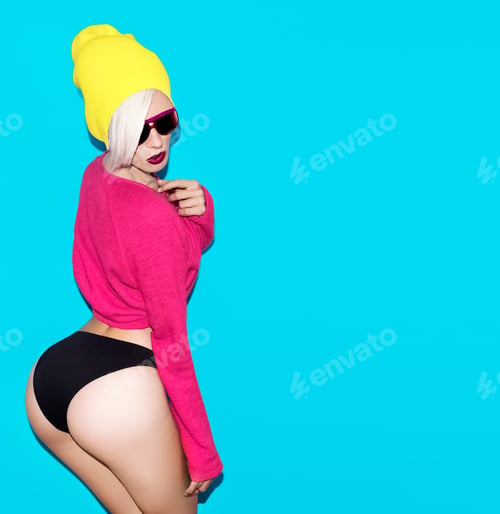 Preview: sexy blond model with a stylish cap and sunglasses on a blue bac