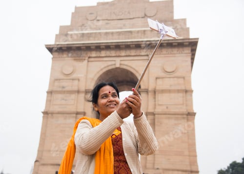 Preview: Tourist taking selfie with smart phone in front of India Gate, Delhi, India.