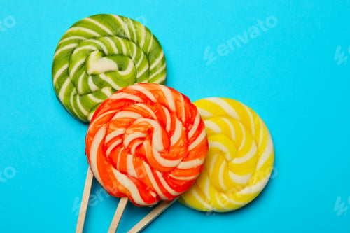 Preview: Tasty lollipops on light blue background, flat lay