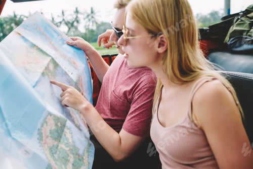 Preview: Traveling couple exploring map in car