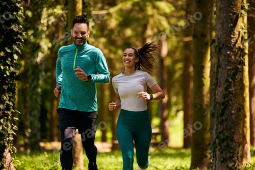 Preview: Happy couple of athletes jogging in nature.