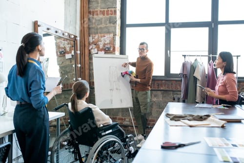 Preview: Young disable male designer with textile samples standing by whiteboard while explaining his view