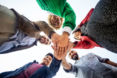 Preview: United diverse happy young people stacking hands