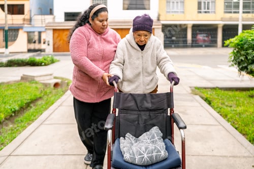 Vorschau: Krankenschwester hilft älterer Frau im Rollstuhl im Park in der Nähe des Hauses