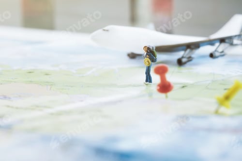 Preview: Mini figure traveler with red pushpin and a map travel concept