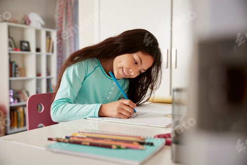 Preview: Young Girl Sitting At Desk In Bedroom Doing Homework