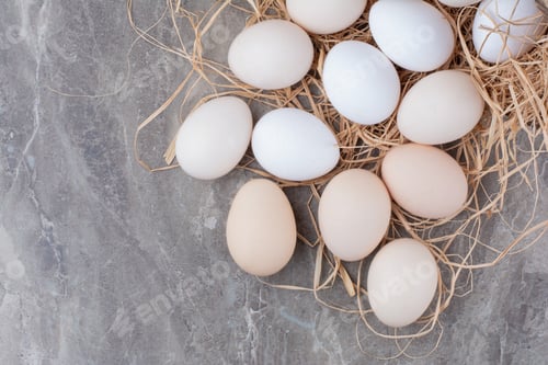 Preview: Several chicken fresh eggs on hay on marble background