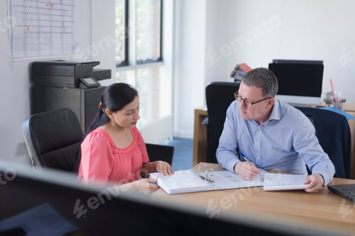 Preview: Colleagues reviewing documents in an office setting.
