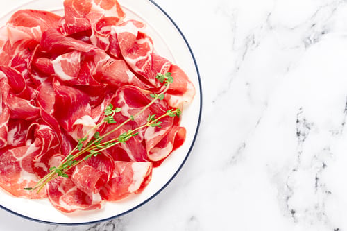 Preview: plate with sliced cured meat, pork neck, prosciutto coppa, Italian delicacy,