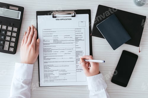 Preview: top view of woman holding pen near document with visa application lettering near smartphone with