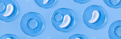 Preview: banner smear of cream round transparent drop in a petri dish on a blue background