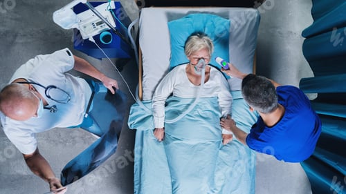 Preview: Top view of doctors and covid-19 patient with oxygen mask in bed in hospital, coronavirus concept.