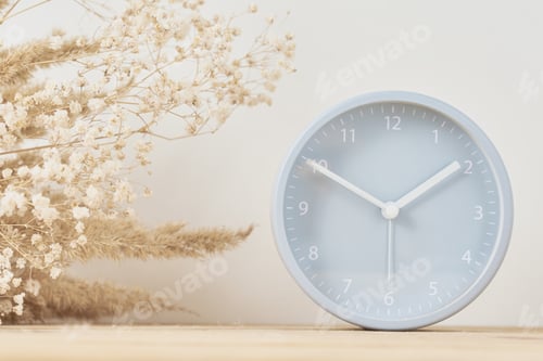 Preview: Alarm clock and homemade vase with dries plant on a wooden table