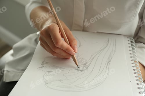 Preview: Woman drawing girl's portrait with pencil in notepad, closeup