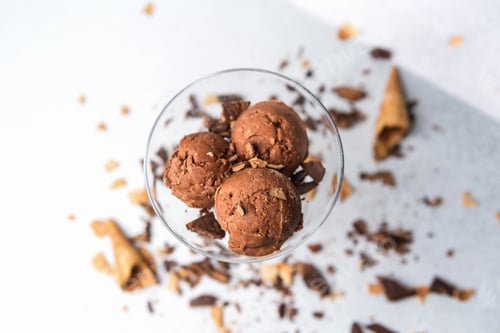 Preview: Top view of chocolate ice cream scoops in glass with waffle and chocolate pieces