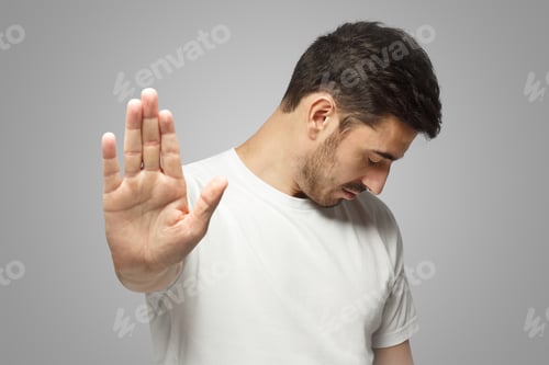 Preview: Man showing stop gesture, isolated on gray background