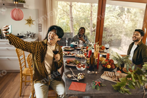 Preview: Smiling young friends taking selfie photo holding wine glasses on holiday dinner party at home