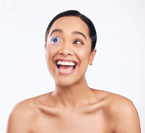 Preview: Shot of bubbles floating over a beautiful woman in the studio