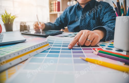 Preview: Graphic designer architects who work with laptops and color comparison tables for design work.