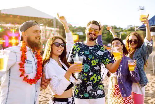 Preview: Young happy friends drinking beer and having fun at music festival together. Friendship.