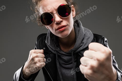 Preview: A young girl with rough facial features, patted brown hair, bright manicure, in a grey bike, black