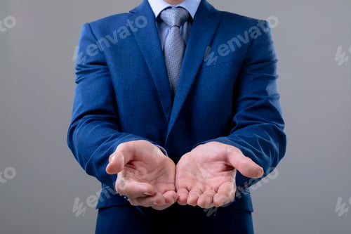 Preview: Midsection of caucasian businessman showing his hands, isolated on grey background