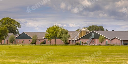 Preview: Modern barns of a farm with silos in dutch agricultural landscape