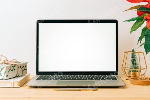 Preview: Notebook computer with mockup blank screen. Laptop on table with Christmas tree, copy space for text
