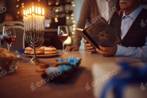 Preview: Close up of mature Jewish couple reading Hebrew bible on Hanukkah.