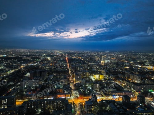 Preview: Vast city lights stretching to the horizon under a dark blue twilight sky