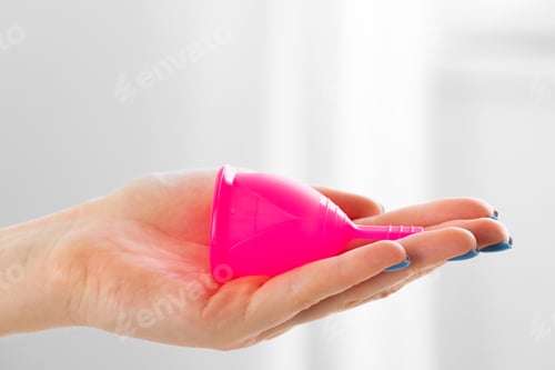 Preview: Woman holding menstrual cup in hand close up