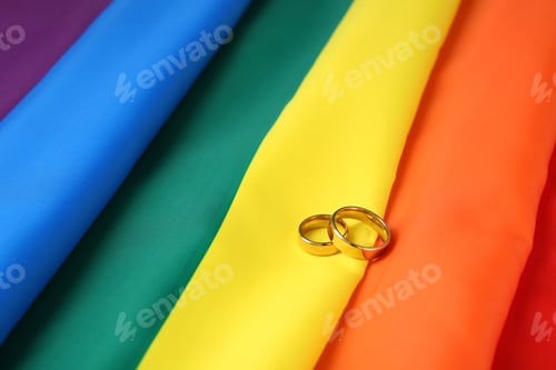 Preview: Wedding rings on rainbow flag. Gay marriage