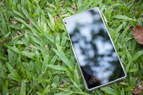 Preview: Phone reflected to the light on green grass