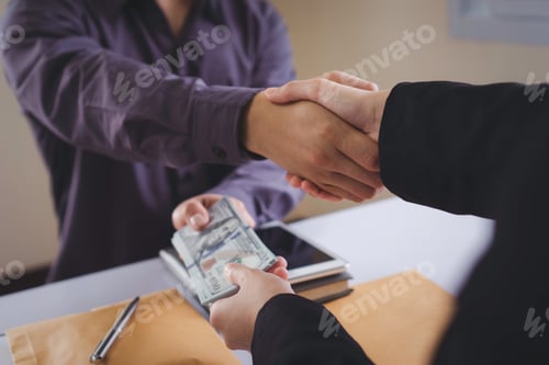 Preview: A corporate businessman shakes hands as a man gives and receives dirty cash to bribe a office, the i