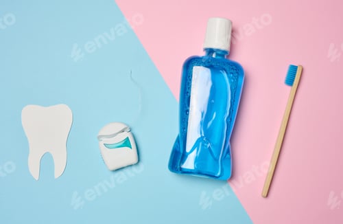 Preview: Plastic bottle with mouthwash, wooden toothbrush on blue background