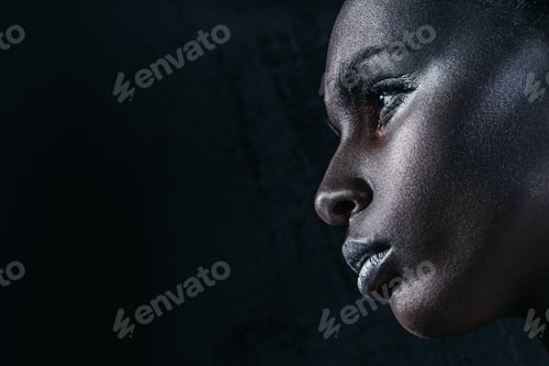 Preview: profile view of attractive african american girl with silver makeup, isolated on black with copy