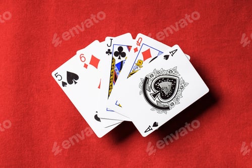 Preview: top view of red poker table and unfolded playing cards with different suits