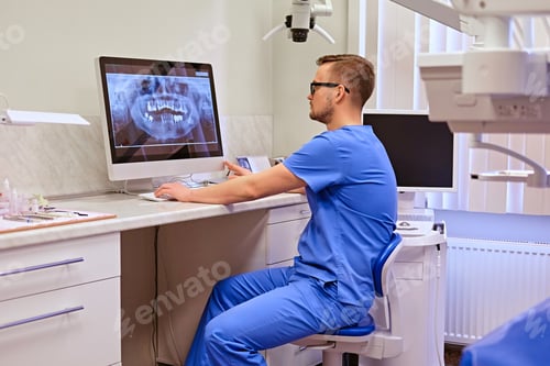 Preview: Dentist looking at teeth x-ray on the computer in a dentist office.