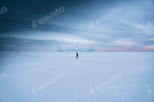 Preview: Man walking through the snow at Ilulissat, Greenland