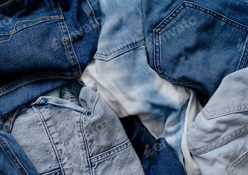 Preview: Stack of old blue jeans, ready for recycling. Circular economy.