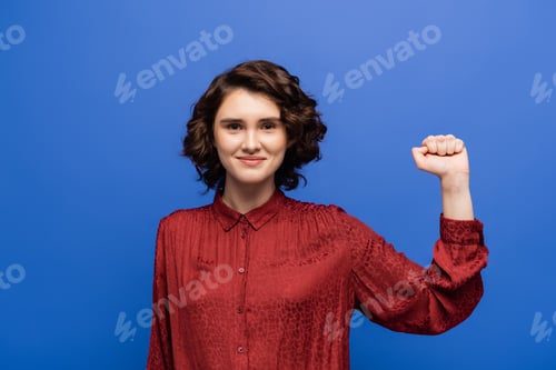Preview: Young Woman Showing Empowerment On Blue Backdrop