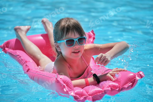 Preview: Young child girl falling in water from inflatable air mattress in swimming pool