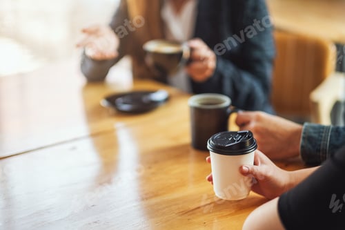 Preview: Closeup image of people enjoyed talking and drinking coffee together in cafe