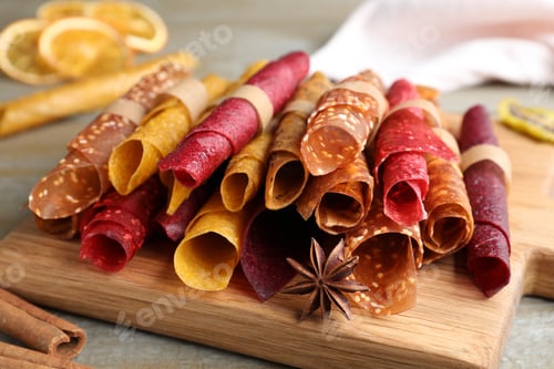 Preview: Delicious fruit leather rolls on wooden table, closeup