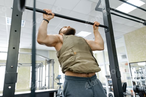 Preview: Military sport, muscular caucasian bearded adult man doing exercises in the gym