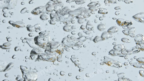 Preview: Air bubbles rising water surface closeup. Bubbling mineral liquid in light