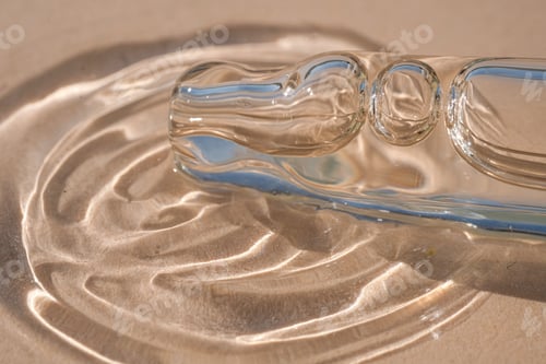 Preview: A dropper and a drop of cosmetic oil on a beige background.