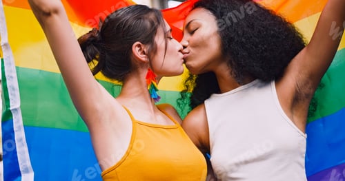 Vista previa: A lesbian couple waves a rainbow flag, a symbol of homosexuality, during a pride parade.