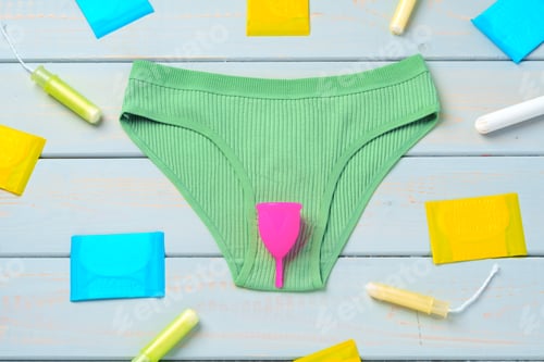 Preview: Menstrual cup and panties on wooden background.