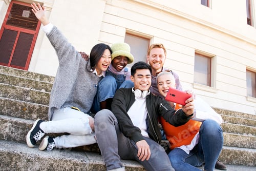 Preview: Multiracial group selfie of smiling people on spring day. Young people gathered together using cell.